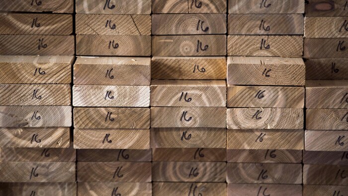 Des planches de bois de cèdre empilées les unes sur les autres avec le numéro 16 écrit au marqueur à l'extrémité de chaque planche.