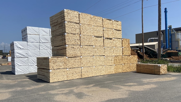 Des piles de bois d'œuvre sont entreposées à l'extérieur de la scierie Arbec à Port-Cartier.