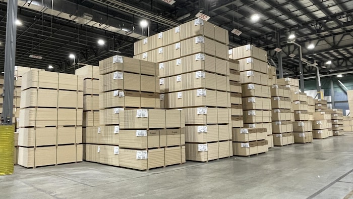 Des panneaux de bois empilés dans une usine.