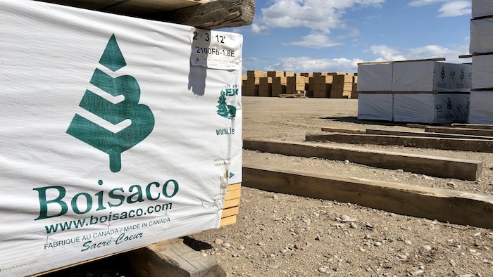 Le logo de Boisaco est apposé sur une pile de planches de bois d'œuvre. 