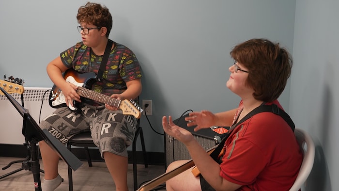 Deux jeunes jouent de la musique.