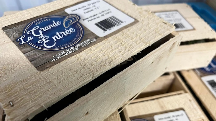 Des boîtes d'huîtres en bois avec une étiquette des Huîtres de la Grande Entrée.