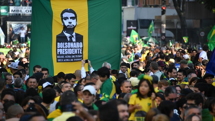 Des supporters de M. Bolsonaro tiennent une pancarte sur laquelle est écrit : « Bolsonaro président ».