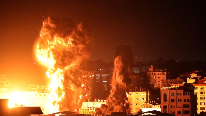 نيران ودخان تتصاعد فوق المباني في مدينة غزة الفلسطينية عقب استهدافها من قبل الطائرات الحربية الإسرائيلية في 17 أيار (مايو) 2021.