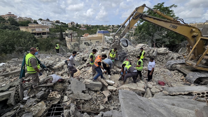 Des secouristes libanais fouillent les décombres au lendemain de frappes israéliennes. 