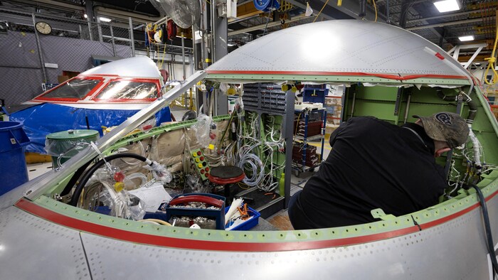 Un ouvrier travaille dans le cockpit de l'avion. 