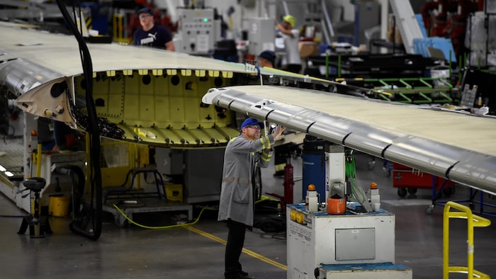 Un travailleur à l'usine de Bombardier à Belfast travaille sur une aile de la C Series.