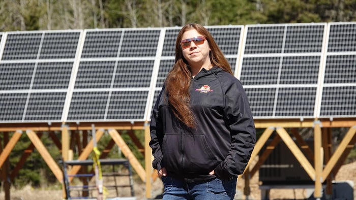 Bonnie Jerome, assistante au département de développement économique du conseil de bande de Gesgapegiag, est photographiée devant les panneaux solaires.