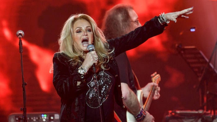 Bonnie Tyler chante dans un micro.