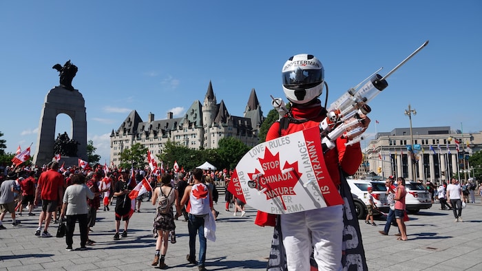 Un manifestant antivaccin déguisé devant le monument commémoratif de guerre à Ottawa.