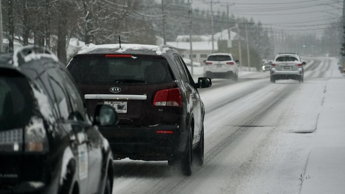 Des voitures roulent sur une route enneigée à Rimouski.