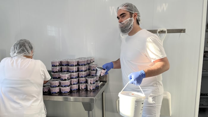 Deux employés de Boréalait avec des contenants de yogourt.