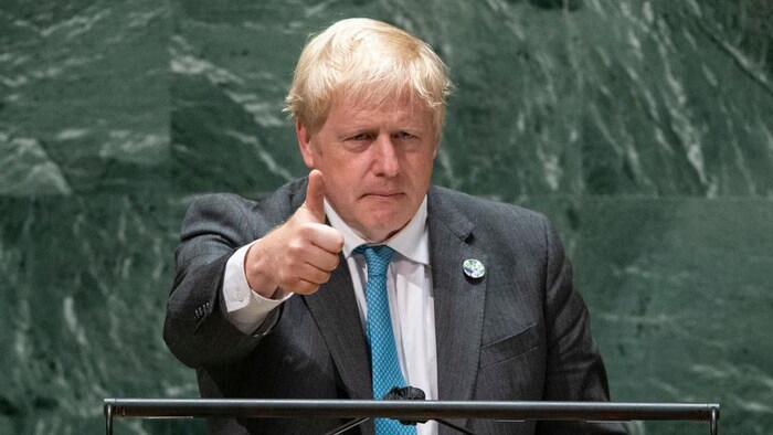 Boris Johnson, l'air sérieux, lève le pouce.