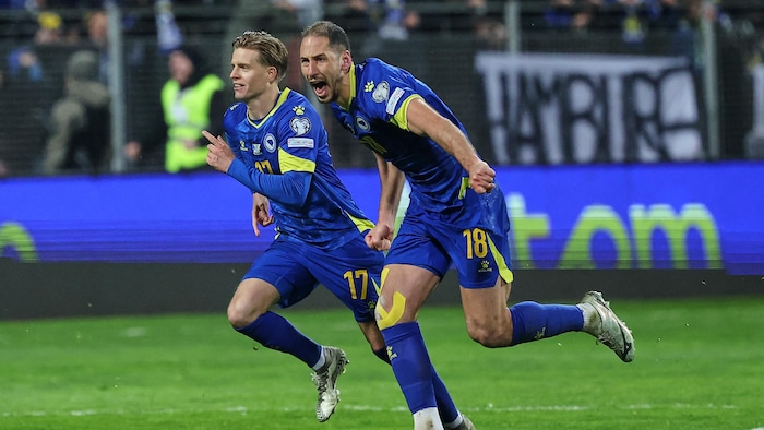 Nikola Katic (à droite) et Dzenis Burnic, tous deux Bosniaques, célèbrent leur victoire aux tirs au but lors du match de barrage de qualification pour la Coupe du monde de football opposant la Bosnie à l’Italie à Zenica, en Bosnie, le mardi 31 mars 2026.