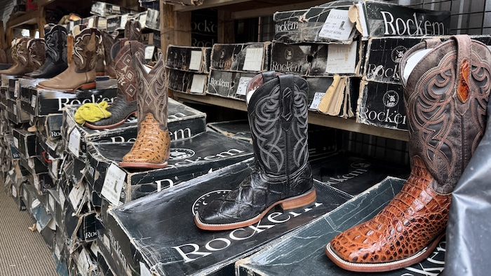 Des bottes de cowboy sur un présentoir dans un magasin.