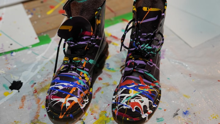 Des bottes marquées de traits de peinture sont déposées au sol.