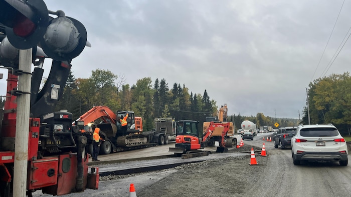 Des travailleurs déplacent de la machinerie sur la route 117.