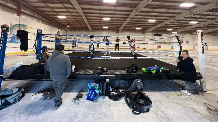 Des boxeurs s'affrontent dans l'arène de Délı̨nę durant l'été 2024. 