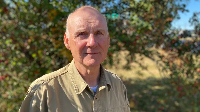Un homme interviewé près d'un cours d'eau.