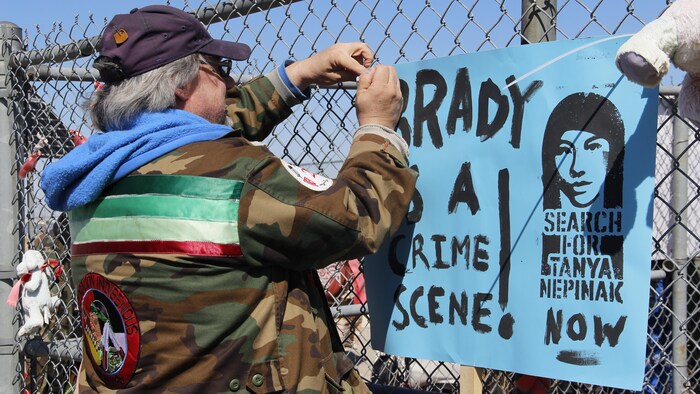 Un homme accroche une pancarte indiquant que Brady est une scène de crime.