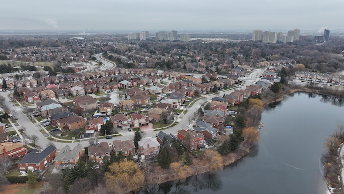 Vue aérienne de maisons de banlieue à Brampton avec des immeubles à logement au loin.