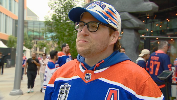 Un homme avec un maillot et une casquette des Oilers d'Edmonton.