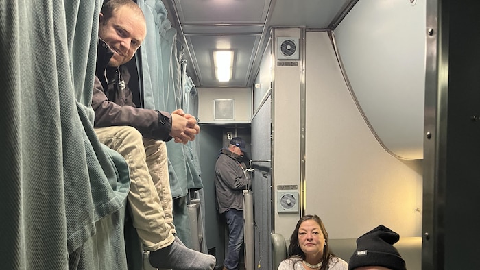 Trois personnes assises dans un train.