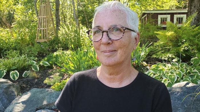 Brenda Murphy dans un jardin de plantes vertes abondantes.