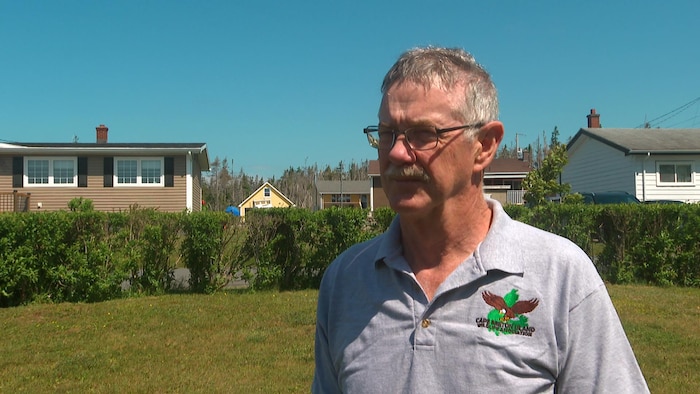 Un homme interviewé à l'extérieur dans un quartier résidentiel.