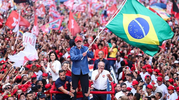 Luiz Inácio Lula Da Silva agite un drapeau brésilien lors d’un rassemblement.