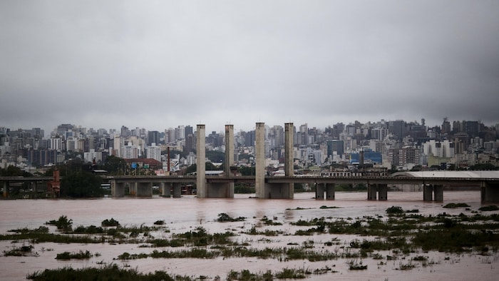 Un pont et en arrière-plan, une ville avec plusieurs bâtiments à étages. 