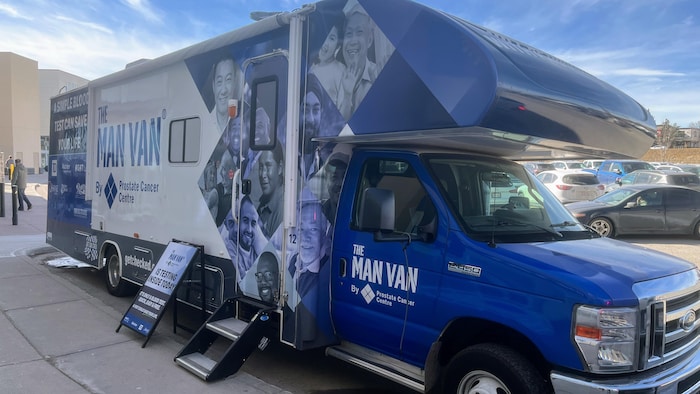 La clinique mobile est décorée de portraits d'hommes et affiche des messages encourageant le dépistage du cancer de la prostate par test sanguin. 