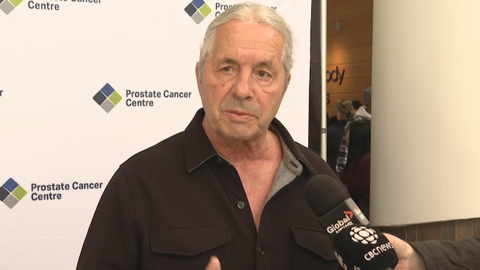 L’ancien lutteur professionnel Bret « The Hitman » Hart s'exprime devant des microphones.