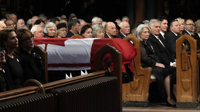 Le cercueil de Brian Mulroney est placé dans l'allée centrale de la cathédrale entouré de proches et de dignitaires. 