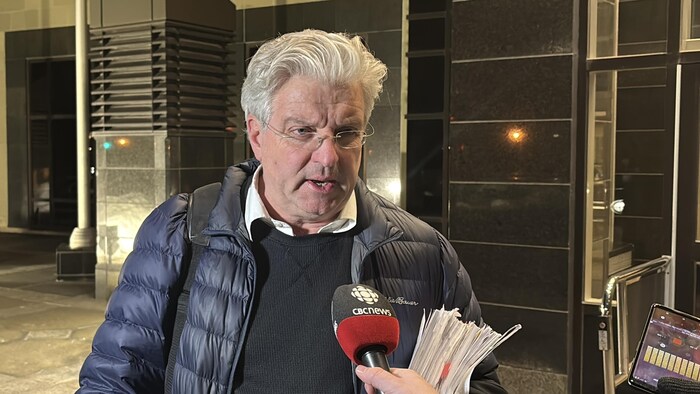 Un avocat aux cheveux blancs en mêlée de presse devant le palais de justice de Moncton.