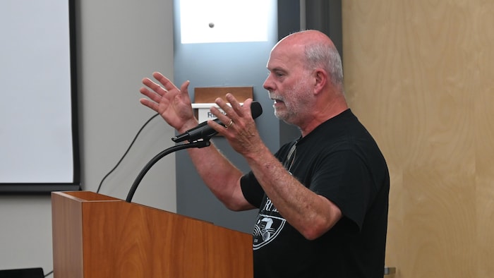 Un homme parle au micro dans la salle du conseil municipal de Grand-Bouctouche.