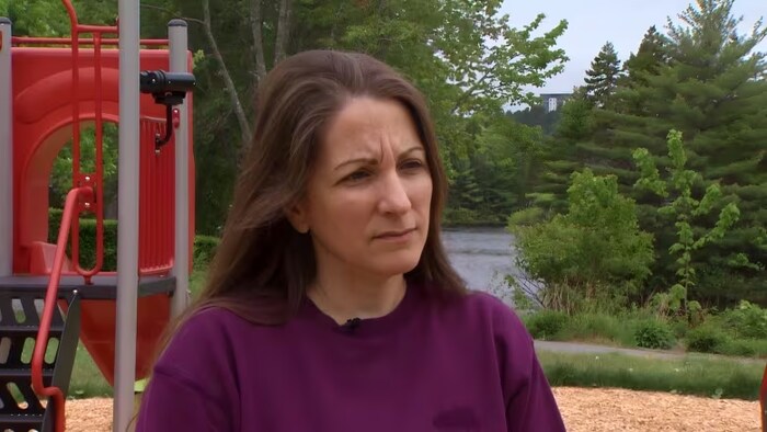 La femme est debout dans un parc.