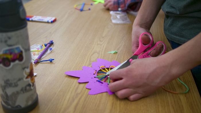 Un enfant manipule des ciseaux lors de son bricolage.