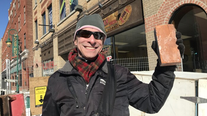 Mario Heins tient une brique de l'ancien hôtel Wellington dans sa main.