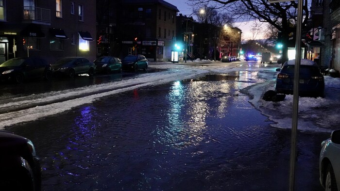 Une rue résidentielle inondée la nuit, à Montréal.