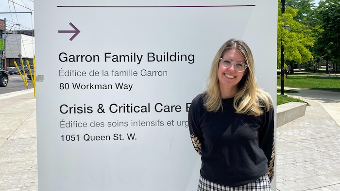 La travailleuse sociale, Britanny Parks, qui pose devant l'entrée du Centre de toxicomanie et de santé mentale de Toronto.