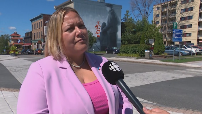 Brittany Blais derrière un micro de Radio-Canada à l'extérieur.
