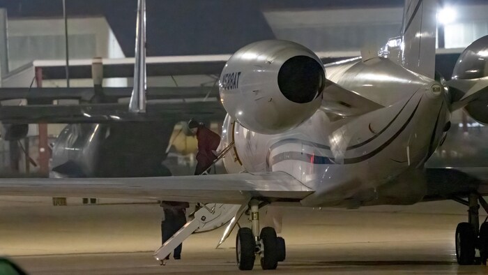 Brittney Griner descend d'un petit avion directement sur le tarmac alors qu'il fait nuit.