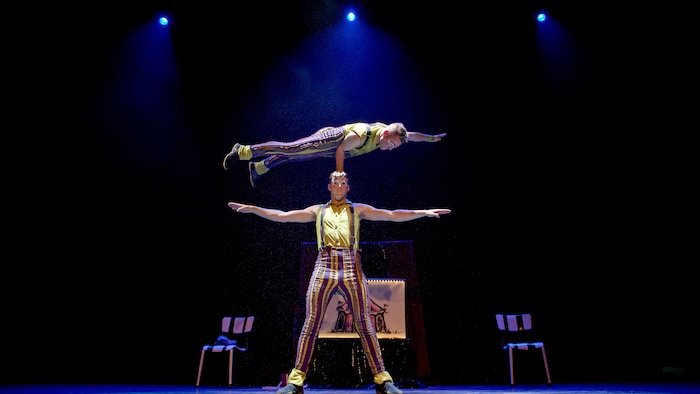Deux clowns exécutent une manoeuvre périlleuse sur scène.