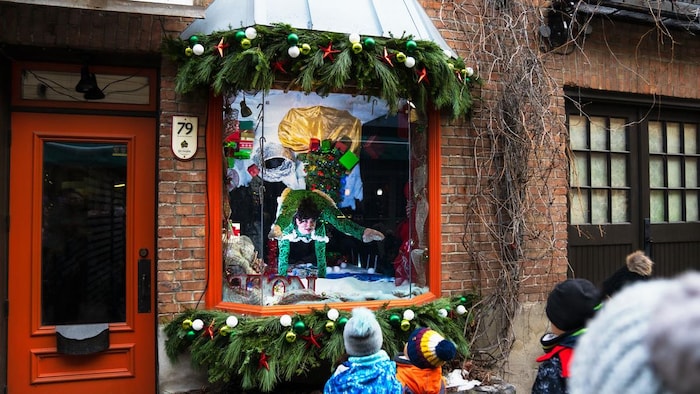 Un contorsionniste fait un numéro derrière une vitrine dans une boutique. 