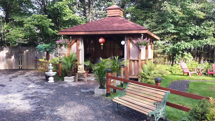 Une petite bâtisse en bois servant de salle de massage, dans la nature.