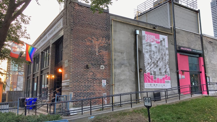 Photo du l'extérieur de théâtre avec une affiche de la saison.