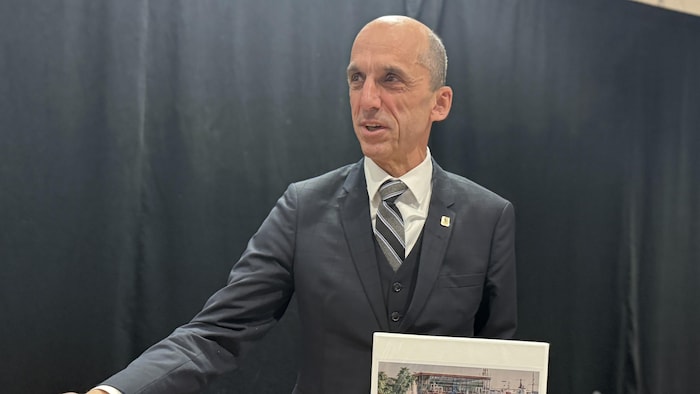 Le maire Steven Blaney tient un cartable sur lequel il est écrit Budget 2026.