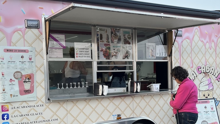 Un camion-restaurant de crème glacée, avec une cliente à l'avant.