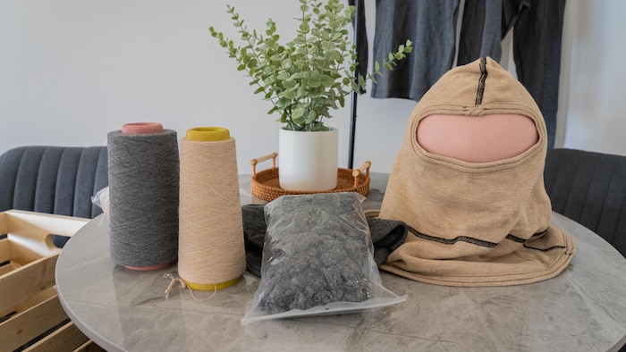 Du fil, de la fibre et une cagoule sur une table.